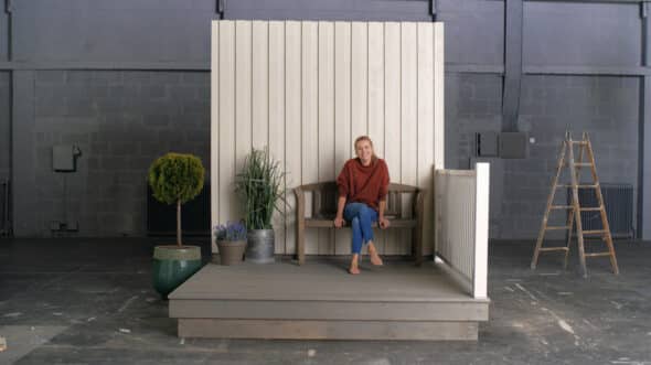 Kvinne som sitter på benken på terrassen
